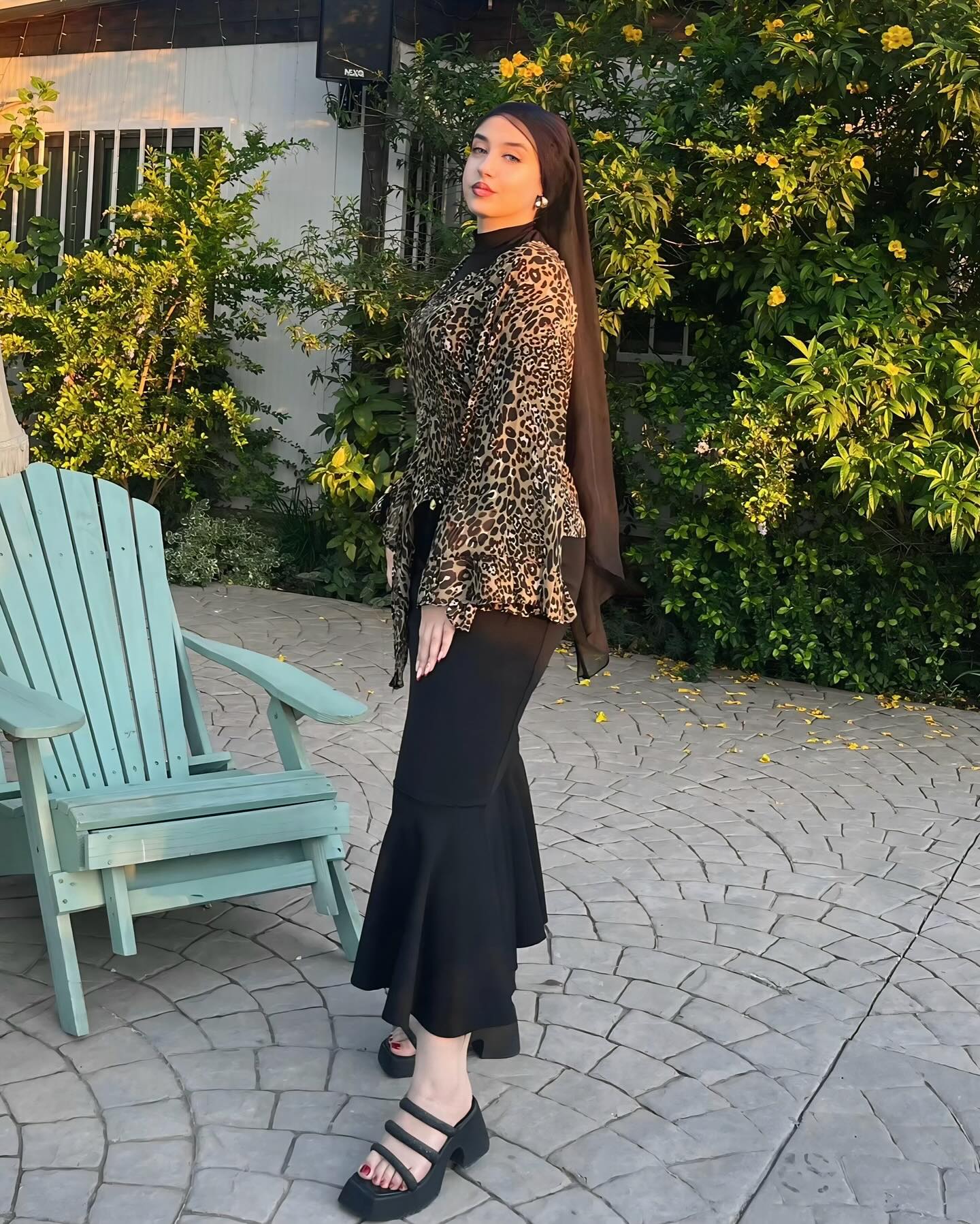 Image of R Y M  |  ريم 💎 from Instagram leopard print, black skirt, strappy sandals, lush garden, outdoor setting