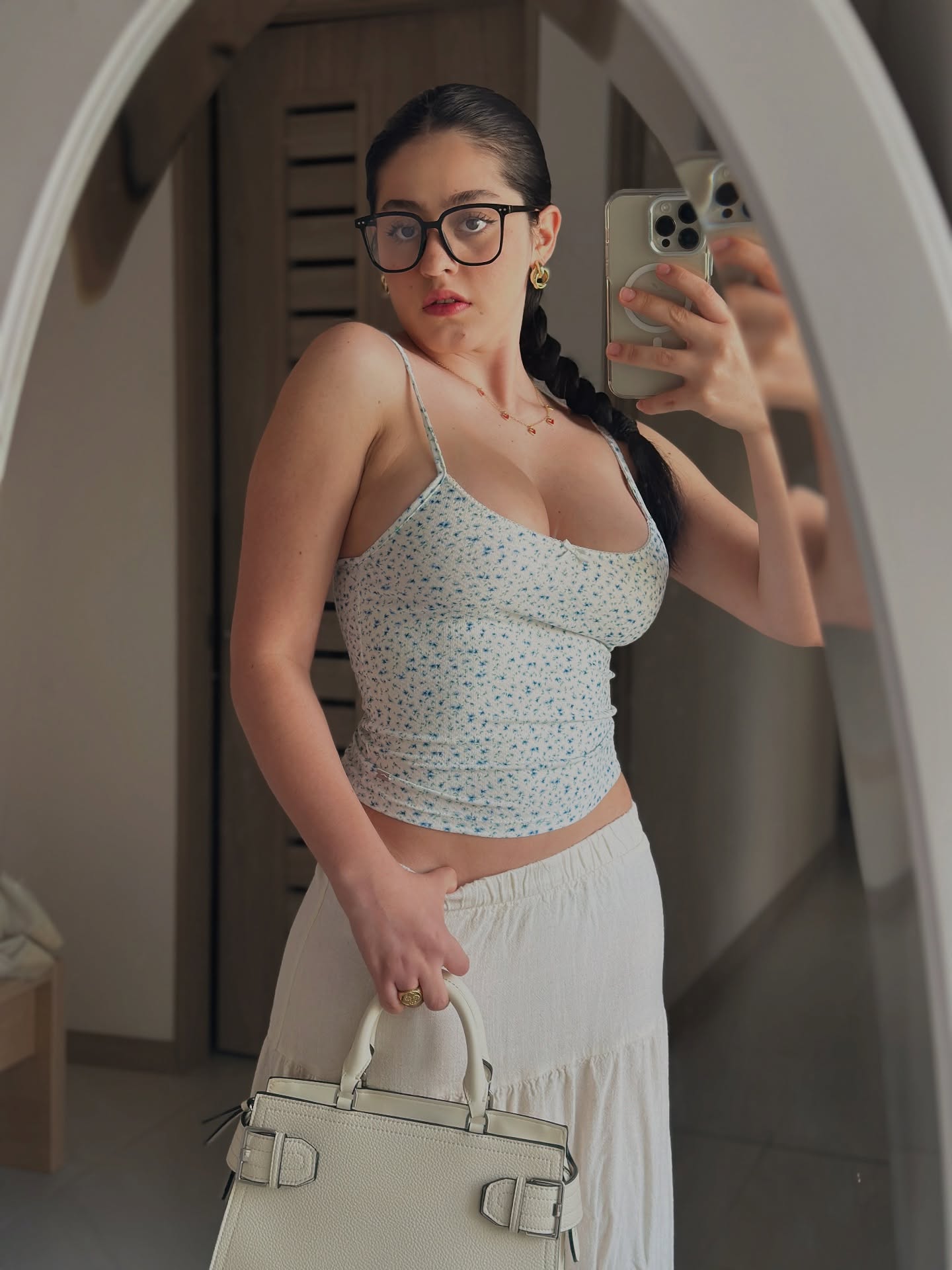 Image of Thalia Cifuentes from Instagram spaghetti strap top, floral pattern, cream skirt, handbag, glasses, gold earrings, ring, phone case, indoor