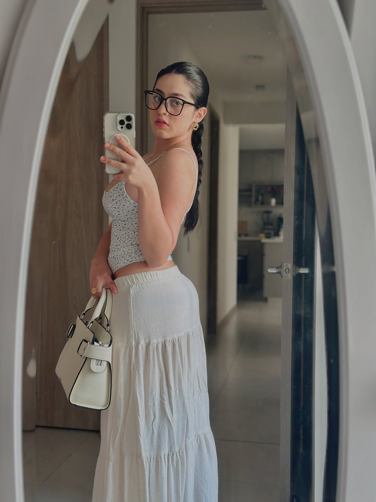 Image of Thalia Cifuentes from Instagram sleeveless top, patterned top, white skirt, handbag, glasses, mirror selfie, indoor