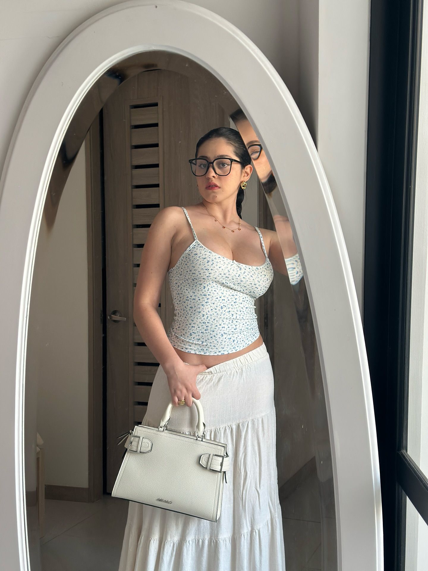 Image of Thalia Cifuentes from Instagram floral top, white skirt, white handbag, glasses, indoor, mirror, accessories, fashion