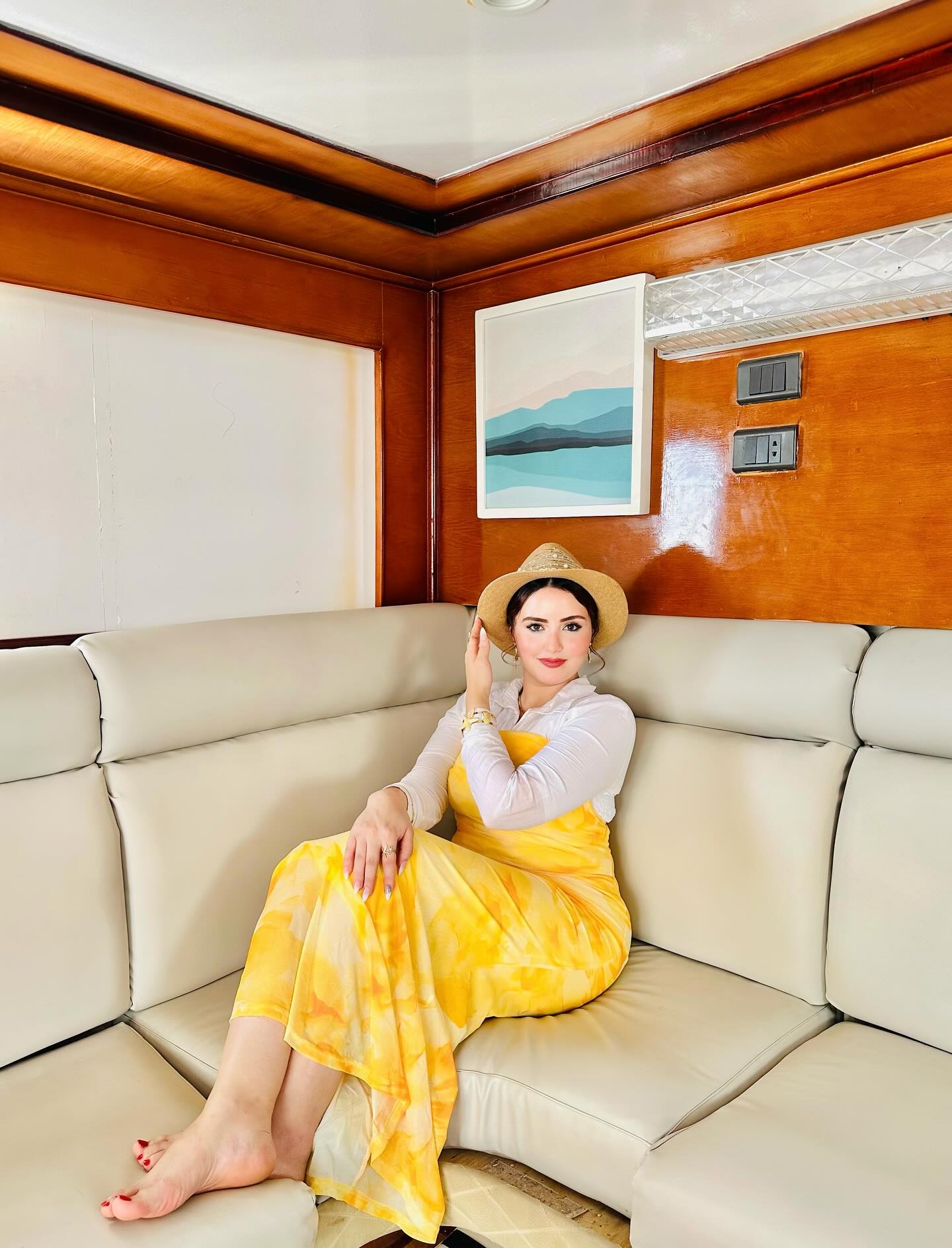 Image of AYA Elboghdady from Instagram yellow dress, white top, straw hat, barefoot, indoor, artwork, bracelet