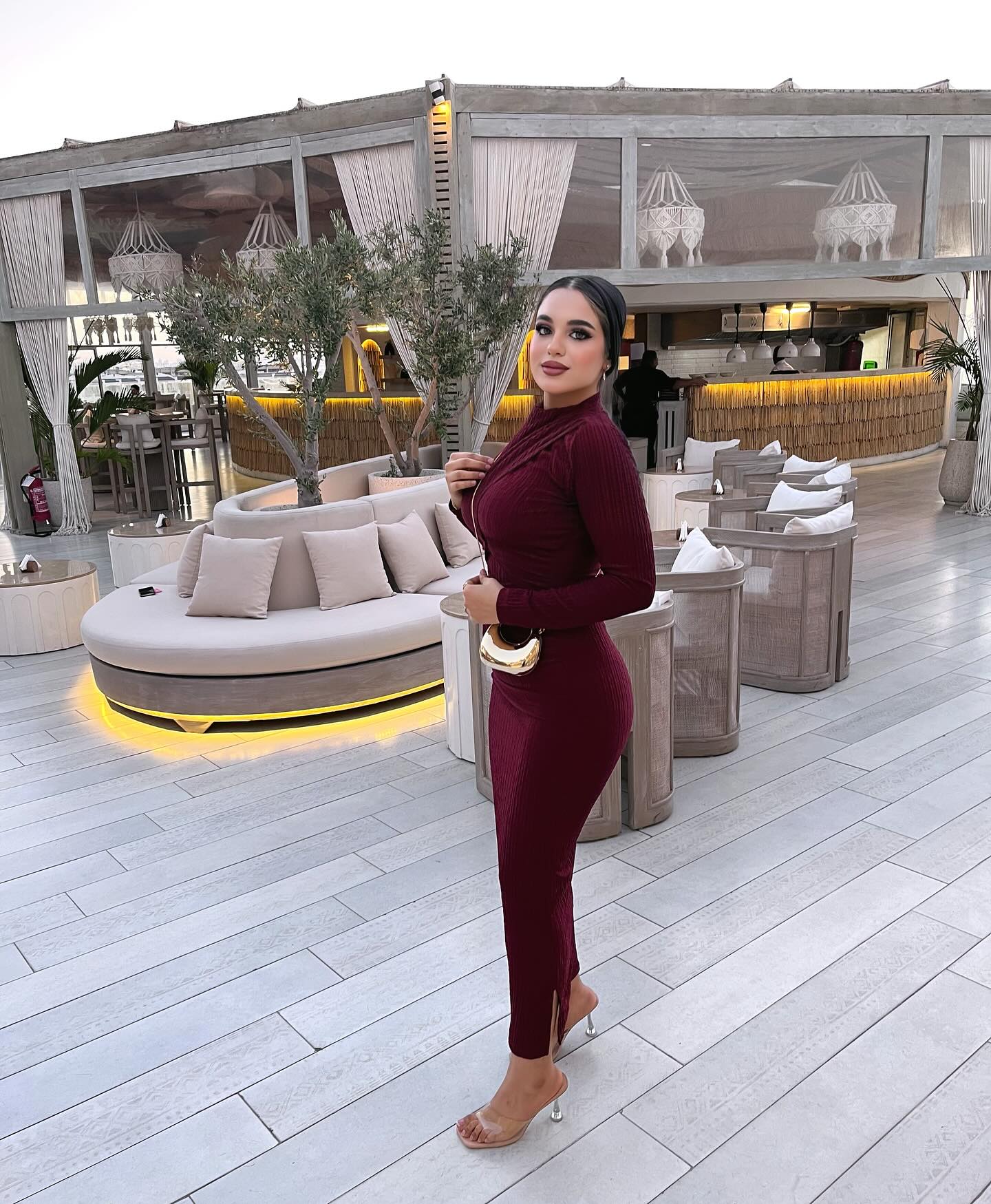 Image of كارلا مصطفي |carla mostafa ✨ from Instagram burgundy dress, long sleeve, gold bag, clear heels, elegant, outdoor lounge