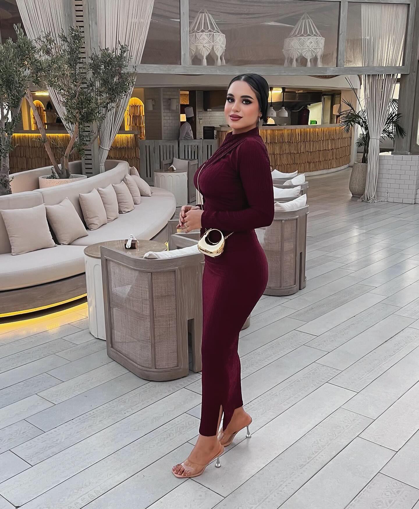 Image of كارلا مصطفي |carla mostafa ✨ from Instagram burgundy dress, high-neck, bodycon, gold bag, clear heels, modern interior, neutral tones