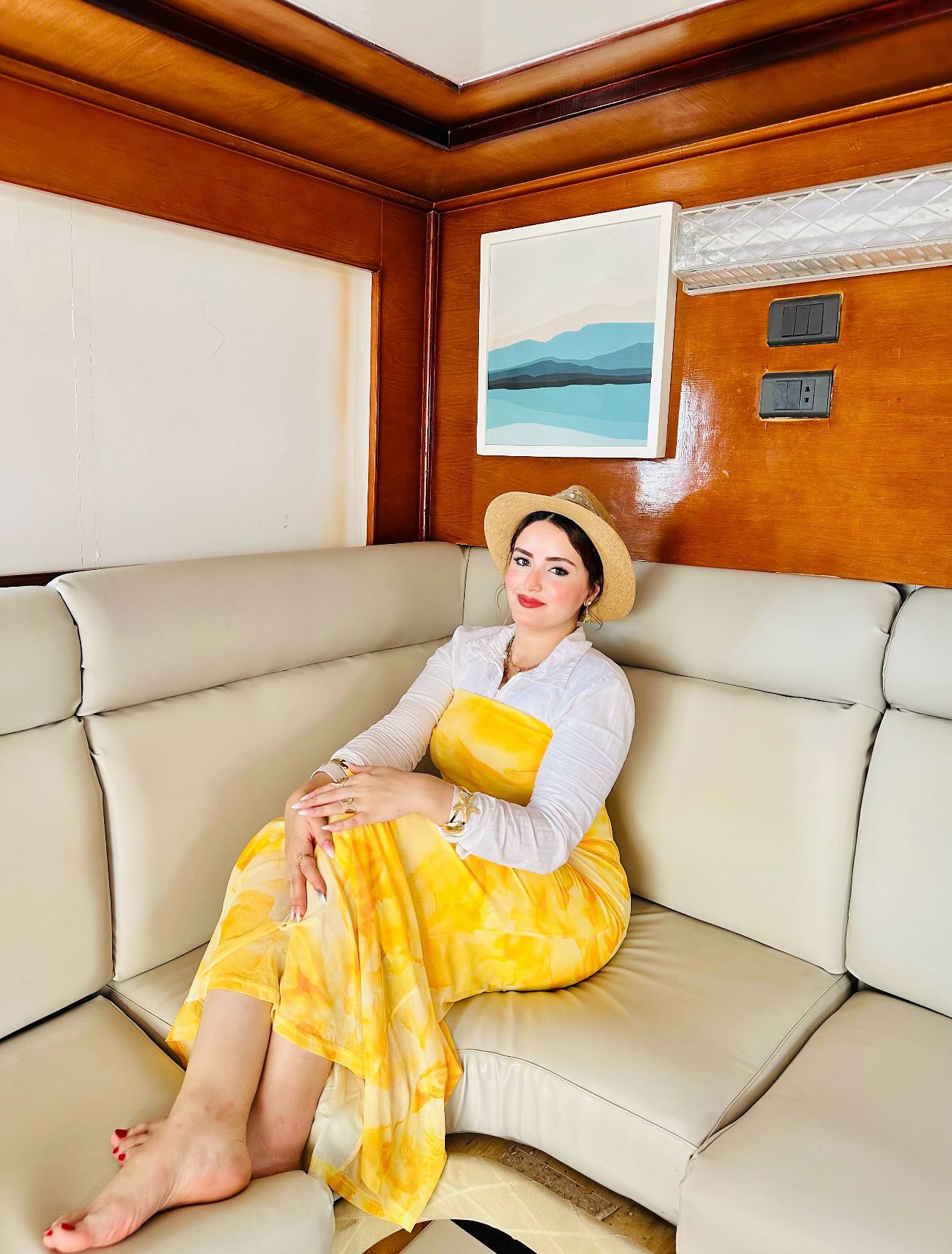 Image of AYA Elboghdady from Instagram yellow dress, white shirt, straw hat, bracelets, barefoot, interior decor, artwork background