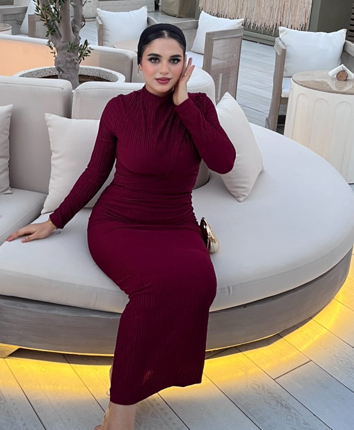 Image of كارلا مصطفي |carla mostafa ✨ from Instagram maroon dress, long sleeves, gathered waist, gold clutch, indoor seating, cozy ambiance