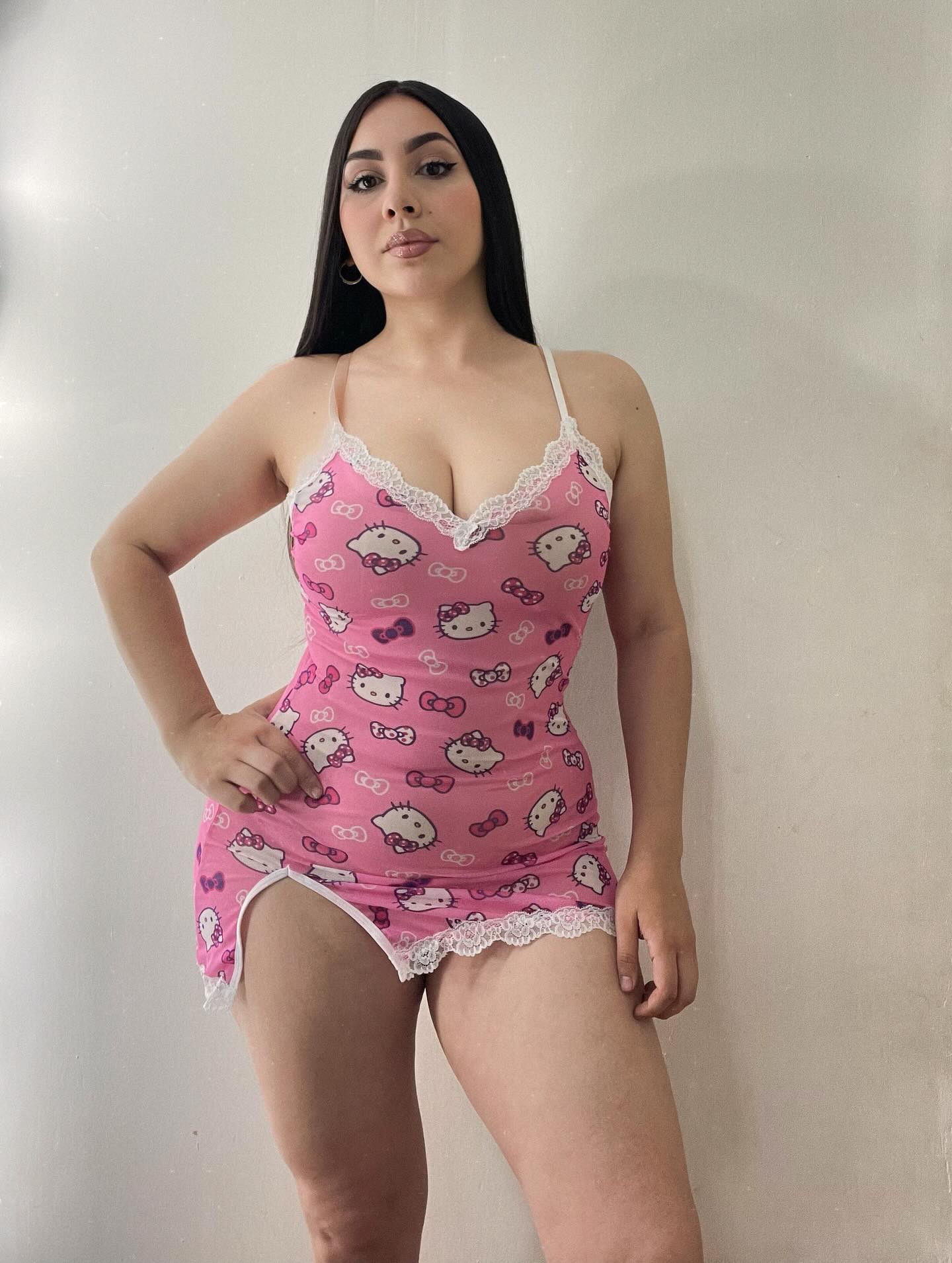 Image of Génesis Ortiz from Instagram pink dress, Hello Kitty design, lace trim, sleeveless, casual, indoor, barefoot