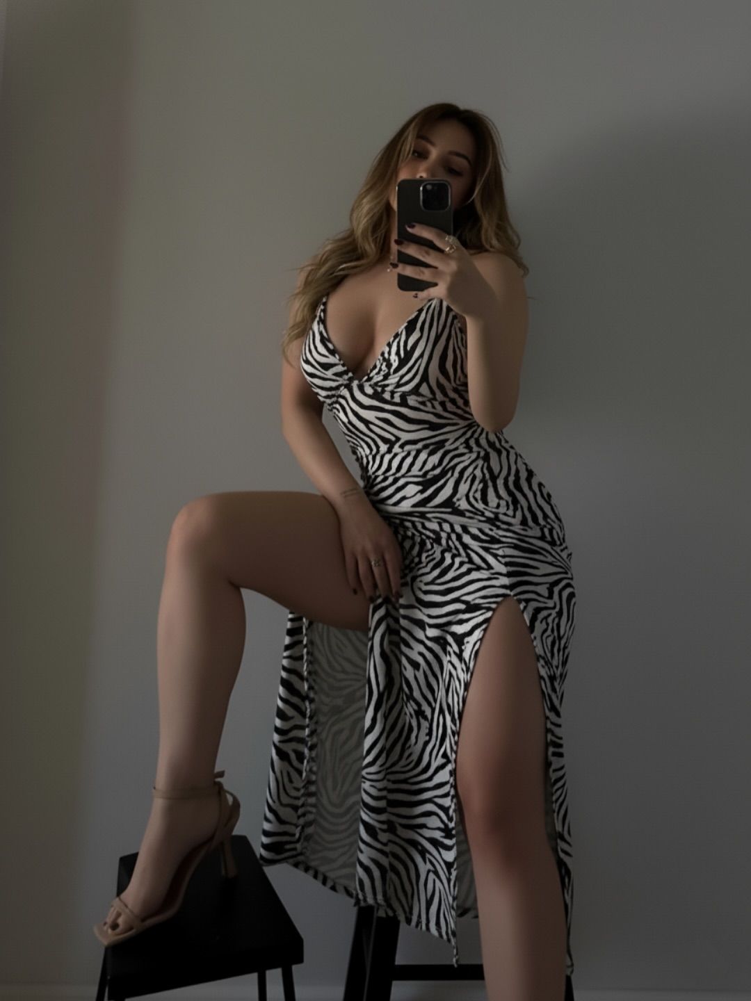 Image of Aania 👅 from Instagram zebra print dress, high slit, strappy heels, minimalist setting