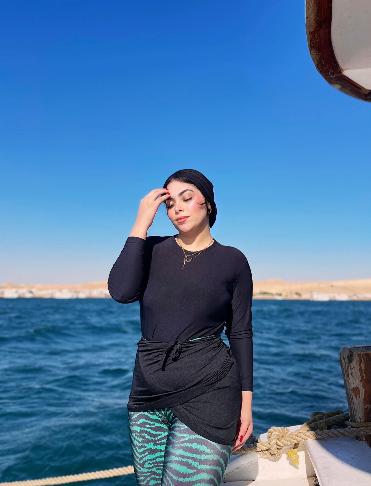 Image of Fatma E Khalifa from Instagram black top, patterned leggings, headwrap, necklace