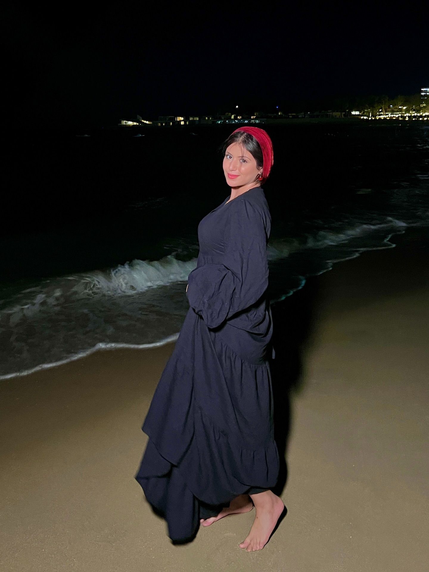 Image of 𝗡𝗢𝗨𝗥 from Instagram black dress, red headscarf, barefoot, beach, night