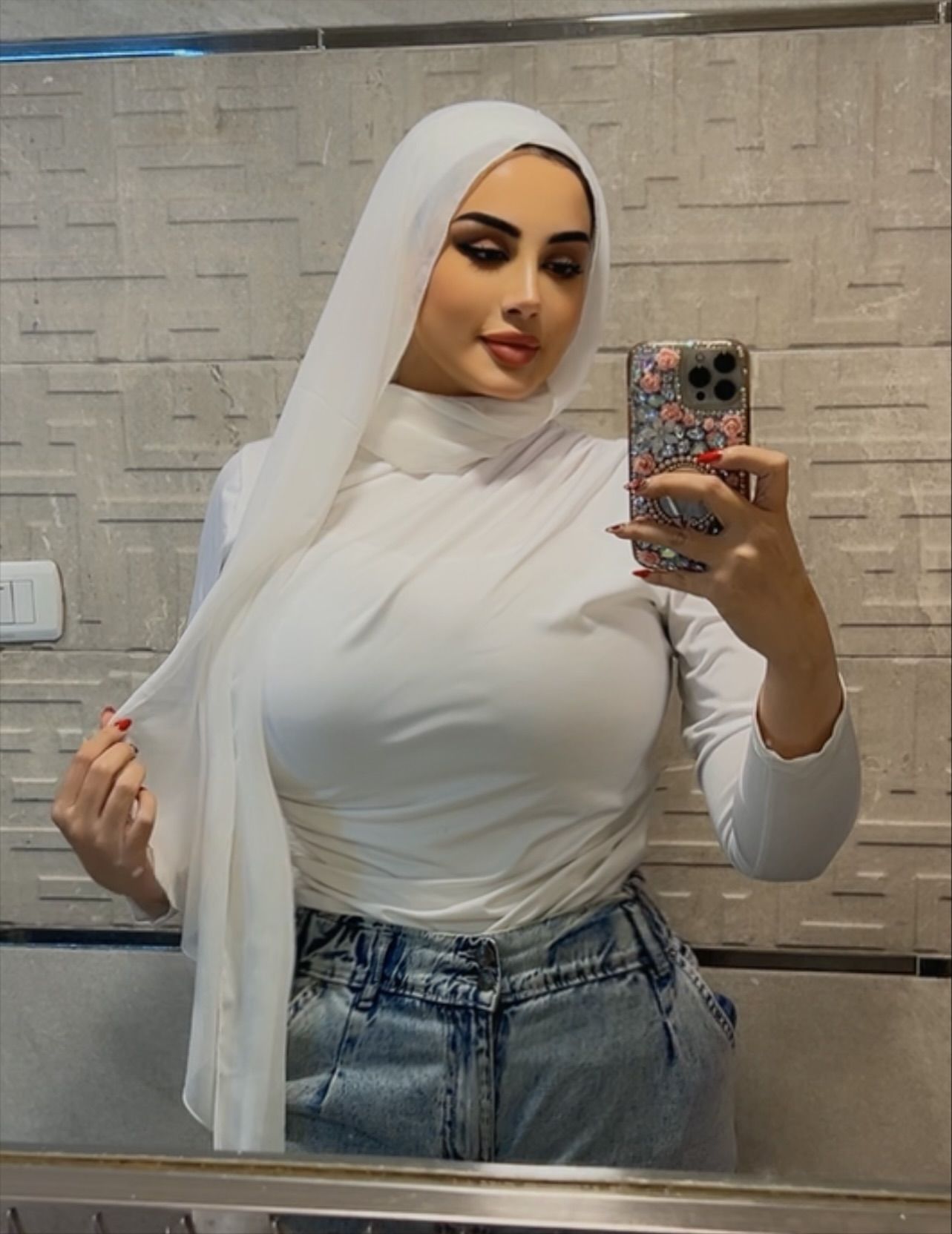 Image of Nourhan Mohamed from Instagram white hijab, white top, denim jeans, mirror selfie, floral phone case