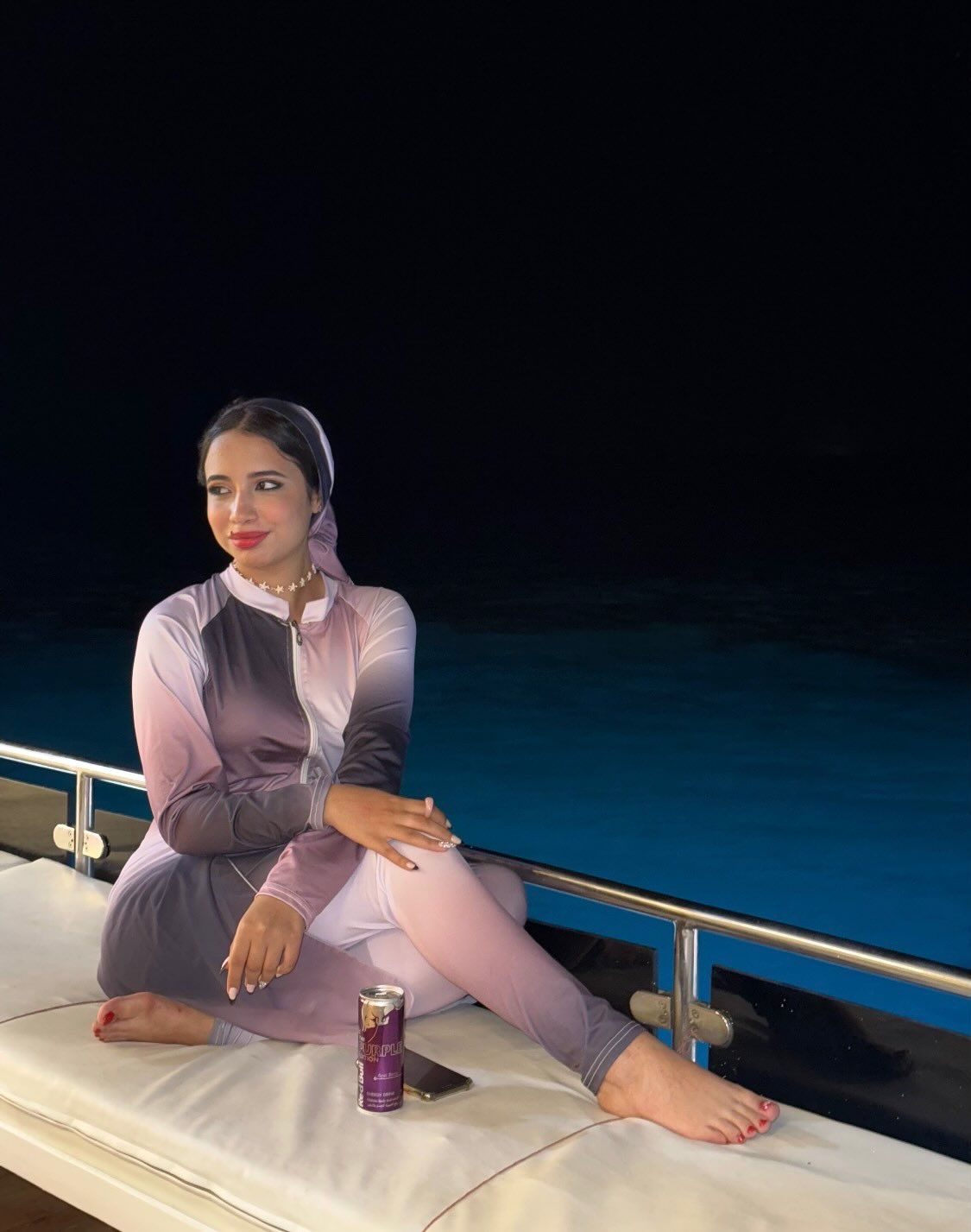 Image of Hoda Hassan from Instagram ombre outfit, hijab, necklace, barefoot, boat setting