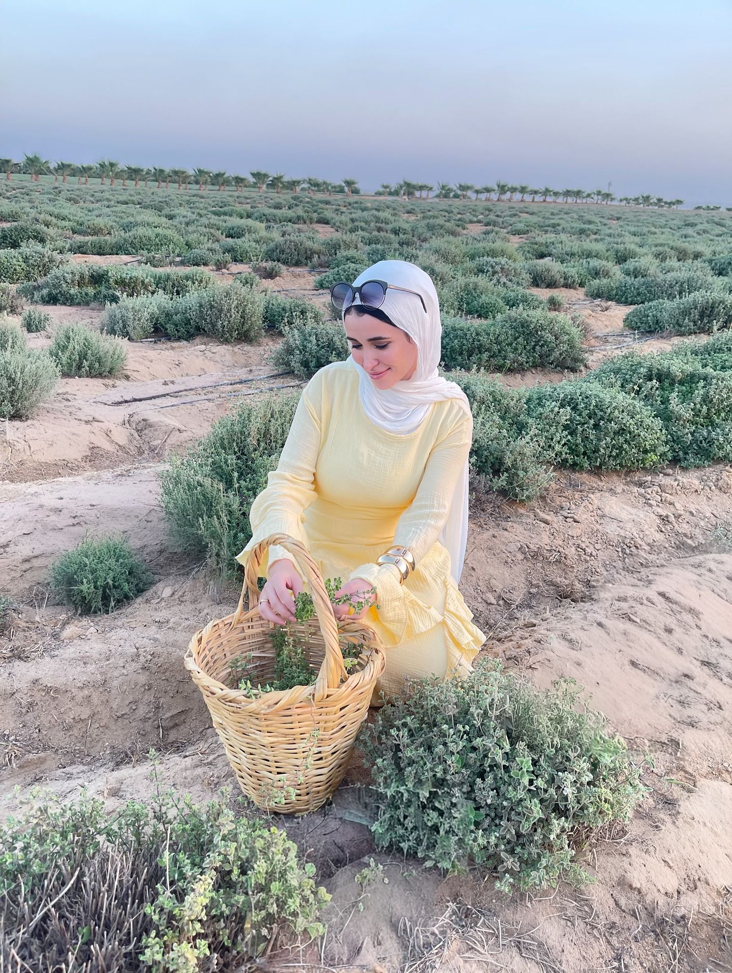Image of 🅝🅐🅓🅐 🅖🅐🅜🅐🅛 🅨🅐🅗🅘🅐 from Instagram yellow dress, white hijab, sunglasses, bracelet, basket, outdoors, garden