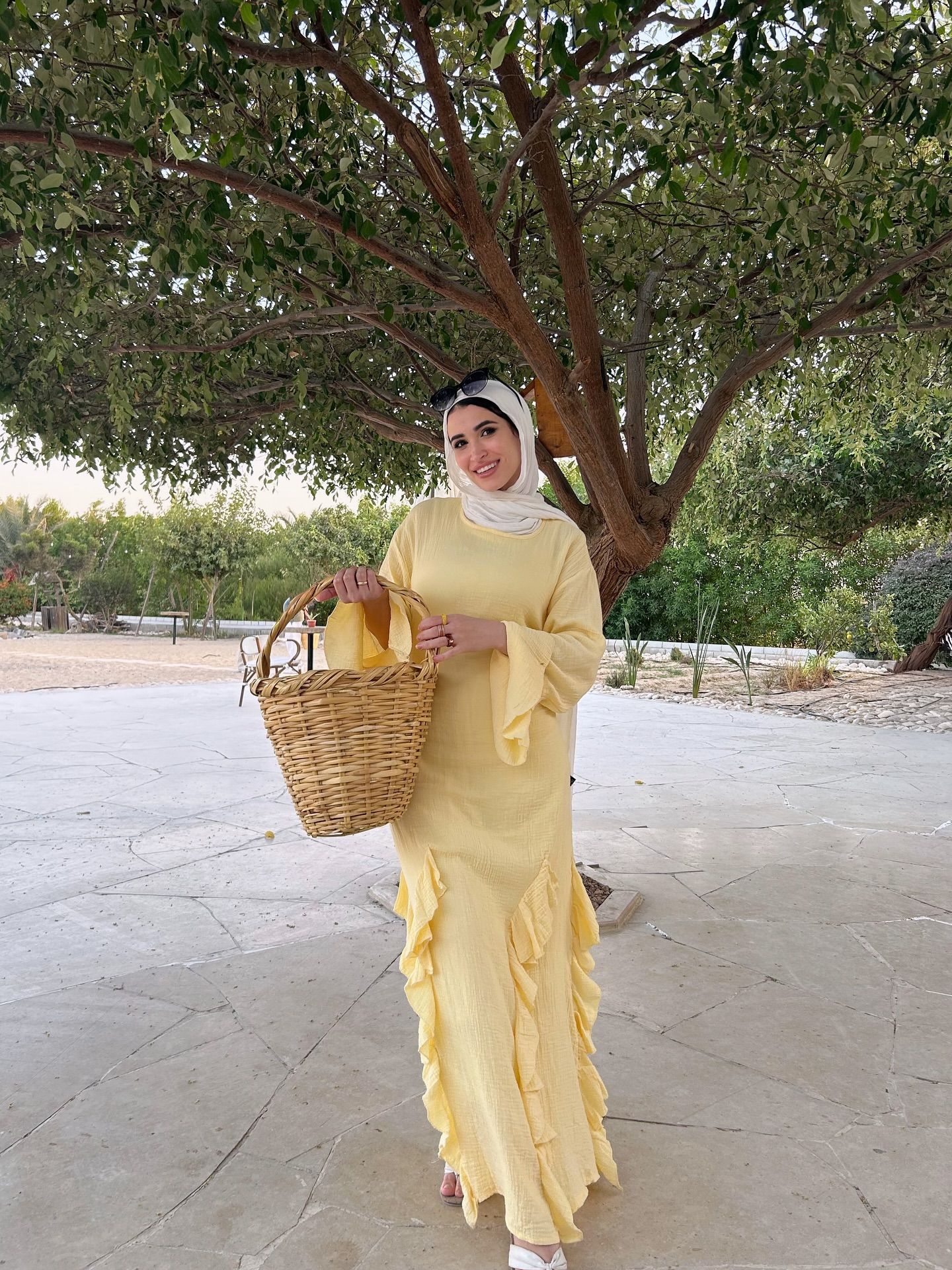 Image of 🅝🅐🅓🅐 🅖🅐🅜🅐🅛 🅨🅐🅗🅘🅐 from Instagram yellow dress, ruffled dress, white sandals, basket bag, headscarf, summer fashion, outdoor setting