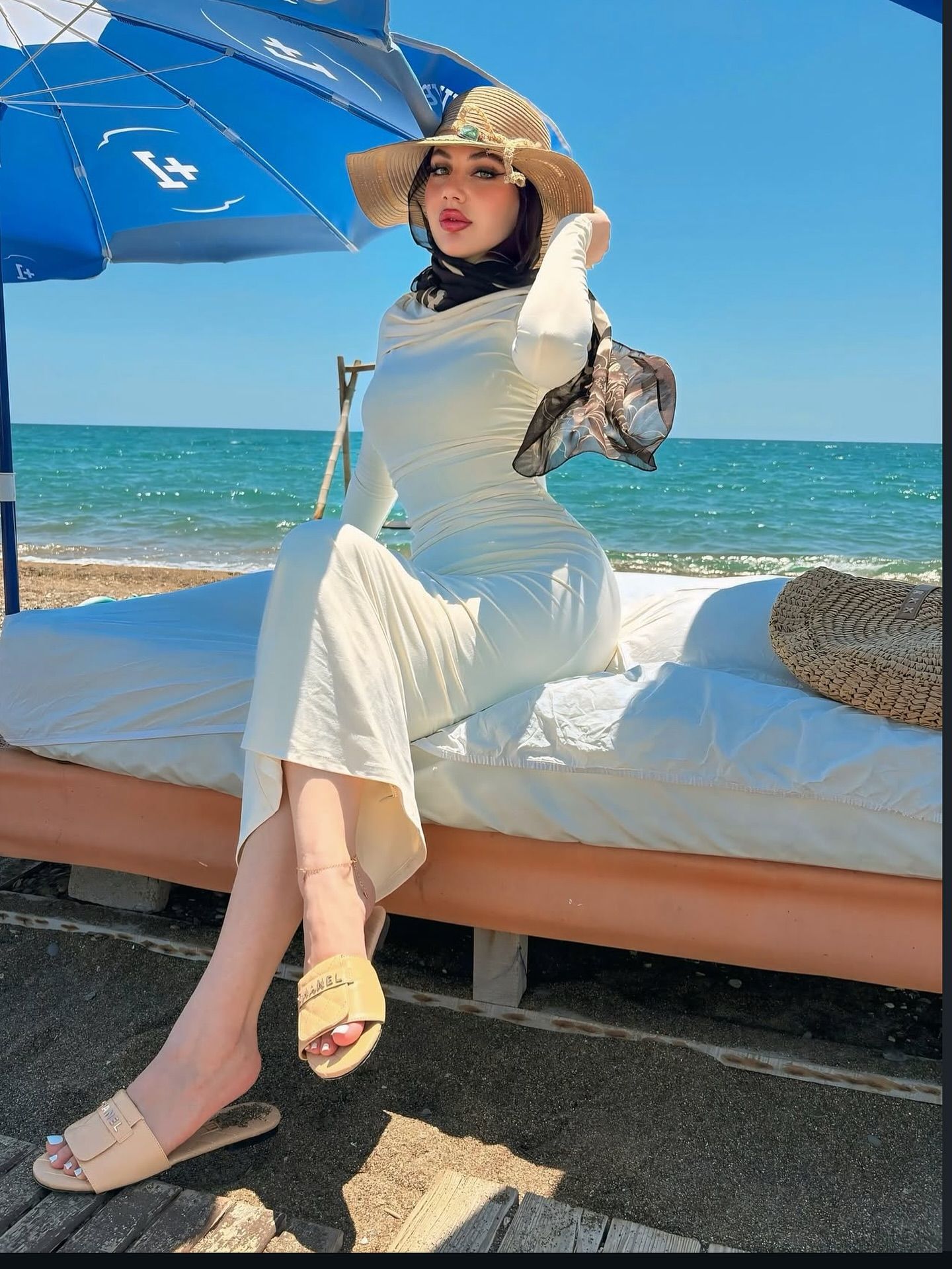 Image of World Models 🩵 from Instagram wide-brimmed hat, straw hat, beach setting, long dress, sandals, black headscarf