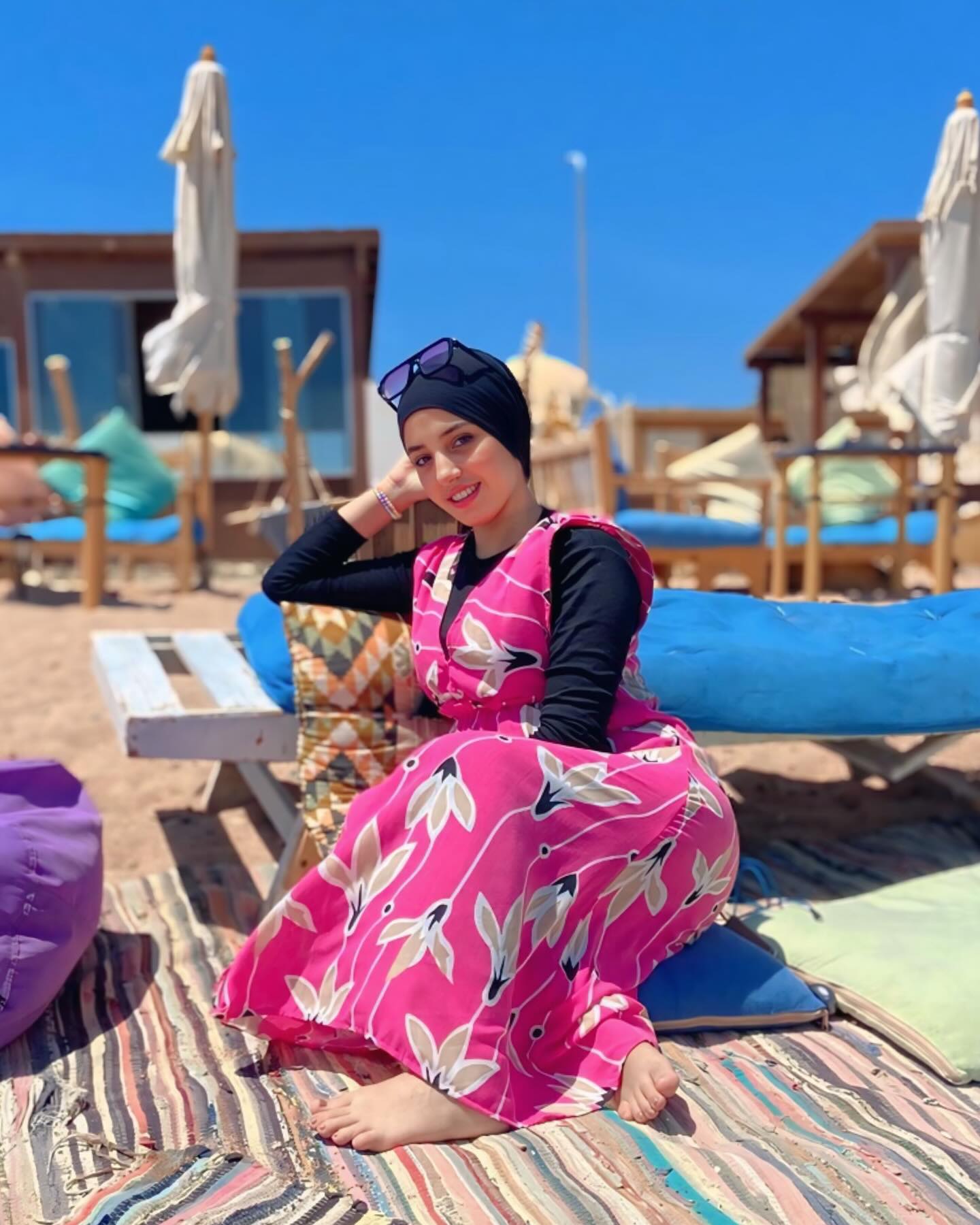 Image of NaDa NabiL-ندي نبيل from Instagram pink dress, black top, headscarf, sunglasses, beach, barefoot