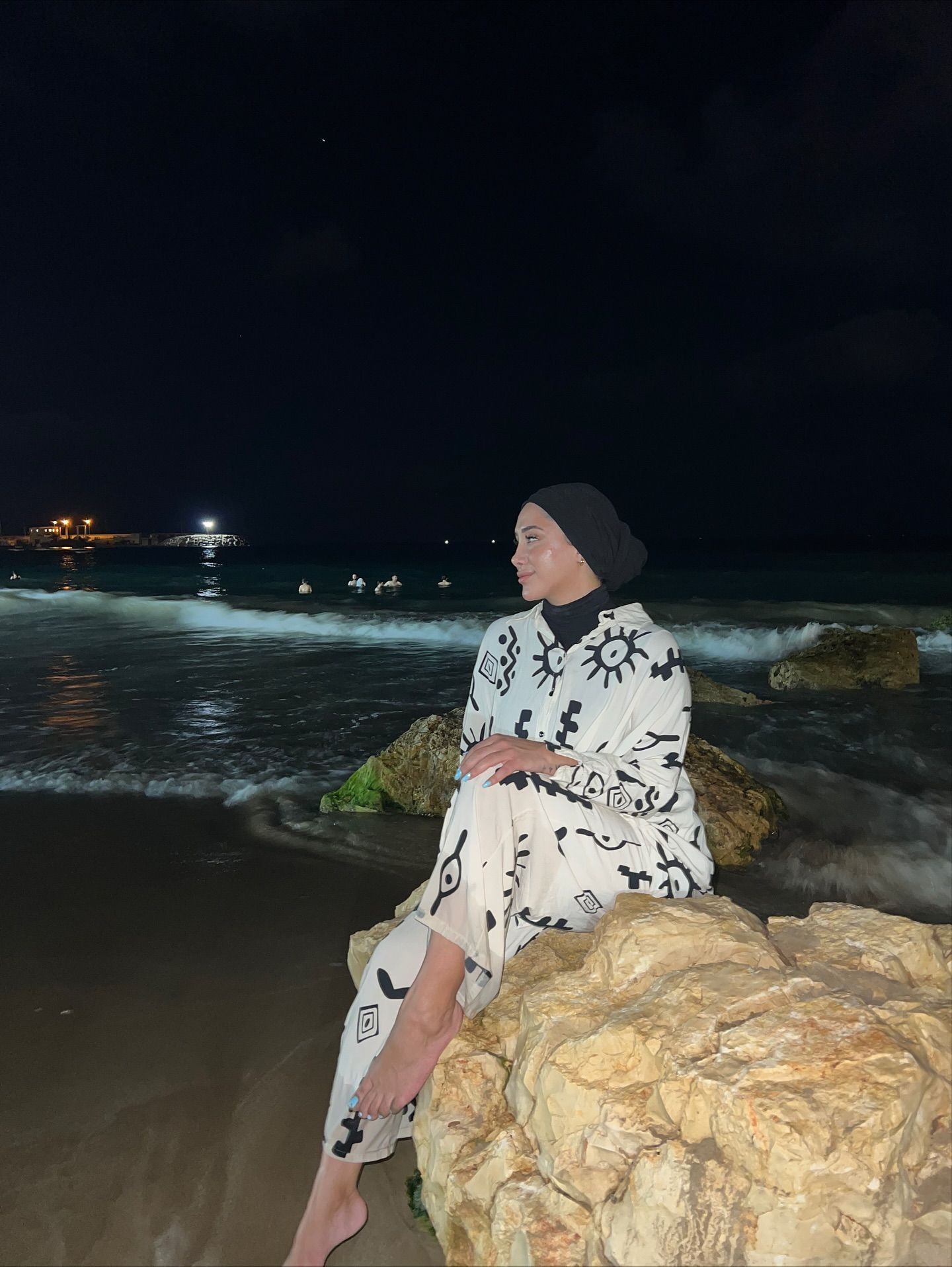 Image of Reem Harisy from Instagram beach, night, patterned clothing, barefoot, hijab
