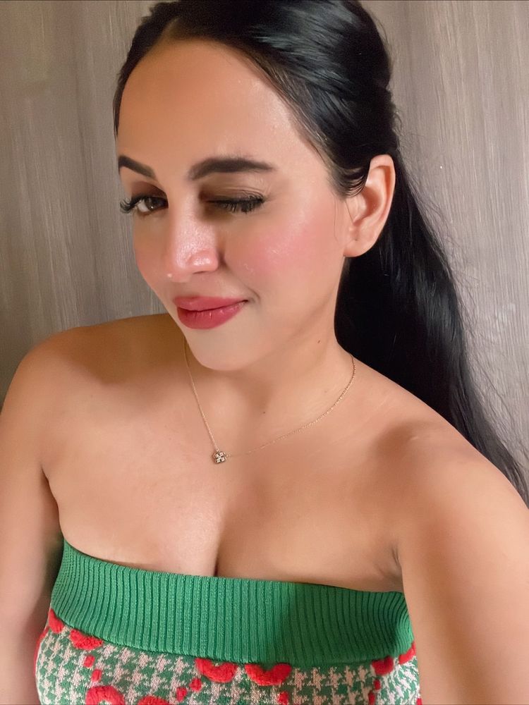 Woman in a green strapless knitted top with subtle accessories