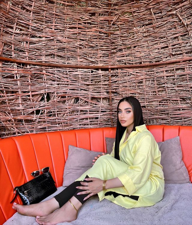 Girl in yellow shirt dress and barefoot in a cozy setting.
