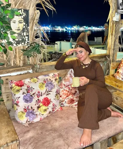 Woman in ribbed knit top and matching pants, barefoot in cozy outdoor seating area.