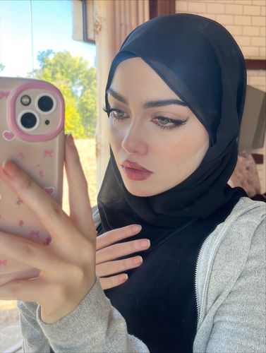 Girl in black hijab and top in indoor setting